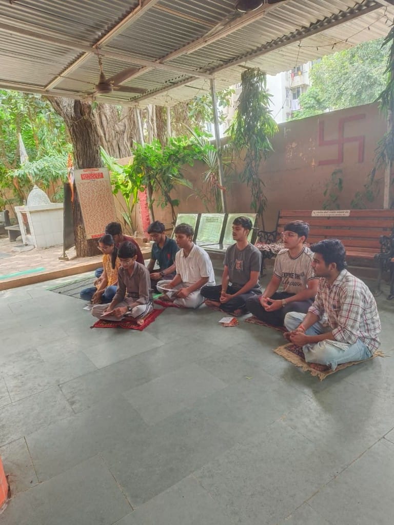 Volunteers seated in prayer and meditation during religious seva at the temple